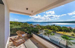 een balkon met stoelen en uitzicht op het water bij Villa Sense in Posedarje
