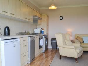 a kitchen with a couch and a chair in a room at Jasmine Cottage in Knitsley