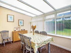 une salle à manger avec une table et des chaises et une fenêtre dans l'établissement Waterside Cottage, à Kyleakin