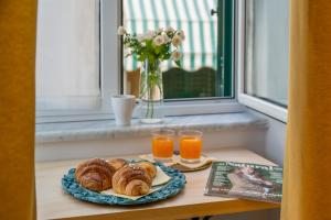a table with a plate of pastries and two glasses of orange juice at Plebiscito Luxury Rooms in Naples