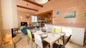 a dining room and kitchen with a table and chairs at Villa avec piscine à deux pas des pistes cyclables in Rivedoux-Plage