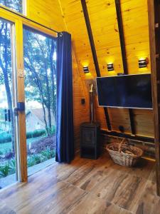 a living room with a flat screen tv and a stove at Chalé Passione in Gramado