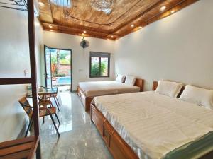 a bedroom with two beds and a table and chairs at Trang An Viet Anh Homestay in Nguyên Ngoại