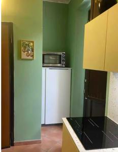 a kitchen with a microwave on top of a refrigerator at Locazione turistica Ida in Amantea +1 photo