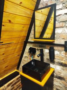 a bathroom with a black sink and a mirror at Chalé Passione in Gramado +39 photos