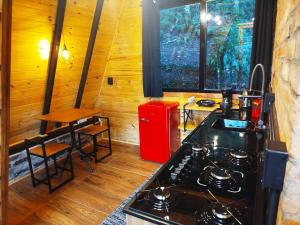 a kitchen with a stove and a red refrigerator at Chalé Passione in Gramado