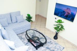 a living room with a gray couch with a mirror at Solace Park Apartments in Gatunga