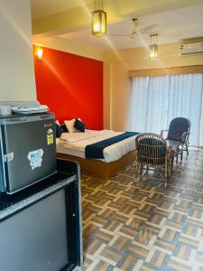 een hotelkamer met een bed en een tv. bij Hotel Anandam Elegance in Morjim