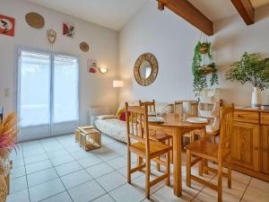 un salon avec une table et une salle à manger dans l'établissement Charmant T2 avec terrasse et jardin à Barbotan - FR-1-841-39, à Barbotan-les-Thermes