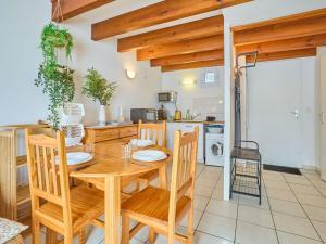 une cuisine et une salle à manger avec une table et des chaises en bois dans l'établissement Charmant T2 avec terrasse et jardin à Barbotan - FR-1-841-39, à Barbotan-les-Thermes