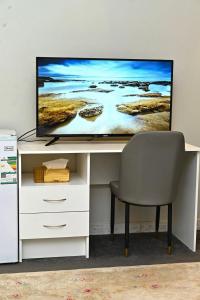 a tv sitting on top of a desk with a chair at قرطبه مودرن - قريبة من المطار in Riyadh