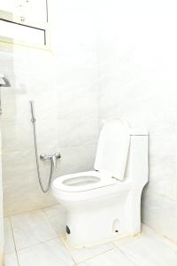 a white toilet in a bathroom with a shower at قرطبه مودرن - قريبة من المطار in Riyadh
