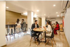 a group of people sitting at a table in a restaurant at FabExpress PP Residency in New Delhi