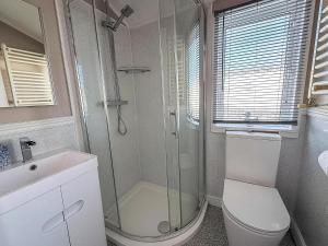 ein Badezimmer mit Dusche, Toilette und Waschbecken in der Unterkunft Stunning Lodge With Decking At Manor Park Near Hunstanton Beach Ref 23066W in Hunstanton + 16 Fotos