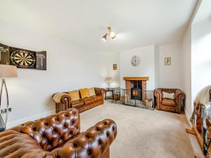 a living room with leather furniture and a fireplace at Binchester Crag Farm in Bishop Auckland