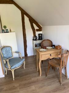 una habitación con un escritorio y una silla y una mesa y una mesa en L'Echo des Bois, en Lyons-la-Forêt
