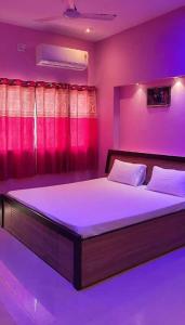 une chambre avec un grand lit avec un éclairage violet dans l'établissement DWARKA HOME STAY AC family only, à Dwarka