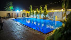 een groot zwembad 's nachts met blauwe verlichting bij The Lala Hotel and Resort in Pushkar +70 foto's