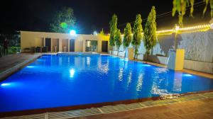 een zwembad 's nachts met blauwe verlichting bij The Lala Hotel and Resort in Pushkar