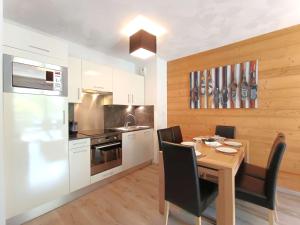 une cuisine avec une table en bois et une salle à manger dans l'établissement Confort et Bien-être à Saint-Lary-Soulan - T3 pour 6 avec WiFi et Parking - FR-1-457-383, à Saint-Lary-Soulan