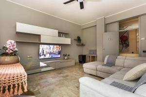 a living room with a couch and a tv at Incanto casa vacanza in Faenza