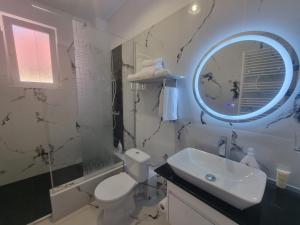 a bathroom with a sink and a toilet and a mirror at LUNA RESIDENCE TERRACE Sinaia in Sinaia +25 photos