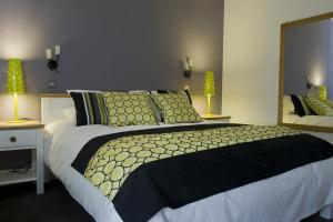 a bedroom with a large bed with green pillows at The Vernon Pub, Restaurant, Hotel in Moffat