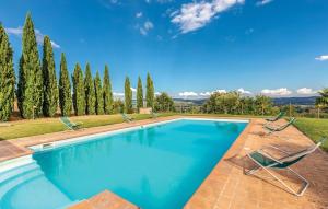a swimming pool with two chairs and trees at Seranna 4 in Papiano
