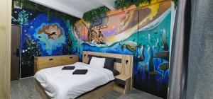 a bedroom with a bed with a painting on the wall at Urban Jungle Social in Bangkok