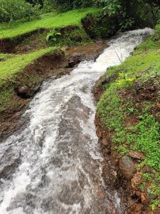 a stream of water on the side of a hill at Girijalsrushti Pool Villa in Kolvan