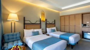 ein Hotelzimmer mit zwei Betten und einem Stuhl in der Unterkunft Sunny Days Palma De Mirette Resort & Spa in Hurghada + 41 Fotos
