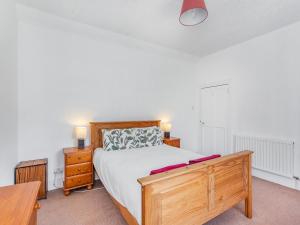 a bedroom with a large bed and a wooden dresser at Lockview Upper Flat in Fort Augustus