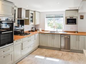 Una cocina con gabinetes blancos y electrodomésticos de acero inoxidable. en Beach Bungalow, en Belton