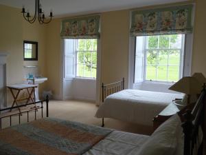 a bedroom with two beds and two windows at Baysdale Abbey in Battersby +18 photos