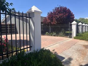 a wrought iron fence with a brick driveway at Riverside in Beaufort West