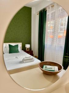a bedroom with a bed with a mirror on a table at N&N City Nest Apartment in Tirane +28 photos