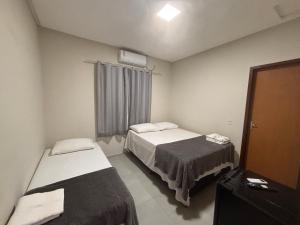 a room with two beds and a window in it at Pousada Lua Bela in Piranhas