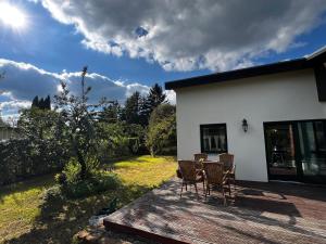 a patio with chairs and a table on a deck at Haus am See in Franzensberg +8 photos