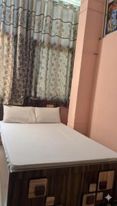 a bed in a small room with a window at Dwarka Home Stay 2 Only family in Dwarka
