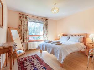 a bedroom with a large bed and a window at Tummel Bank in Pitlochry