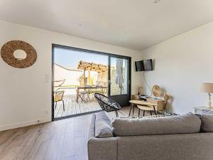 a living room with a couch and a patio at Maison moderne au Bois-Plage-en-Ré avec jardin - FR-1-835-3 in Le Bois-Plage-en-Ré