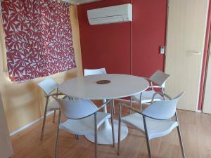 a dining room with a white table and white chairs at LAVATOGGIO in Lumio