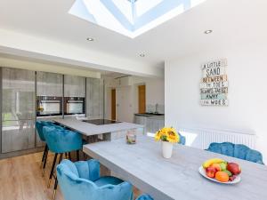 a kitchen with a table and some blue chairs at Sea Breezes in Anderby