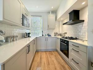 a kitchen with white cabinets and a stove top oven at Shorewaters in Appledore
