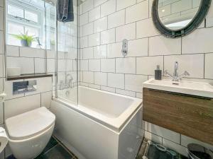 a bathroom with a toilet and a sink and a tub at Shorewaters in Appledore