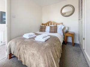 a bedroom with a bed with towels on it at Shorewaters in Appledore