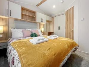 a bedroom with a large bed with towels on it at The Manor Retreat in Banchory