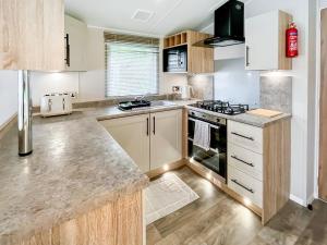 a kitchen with wooden cabinets and a stove top oven at The Manor Retreat in Banchory +9 photos