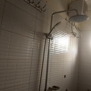 a shower with a shower head in a bathroom at Spea Homely Apartments in Mbarara
