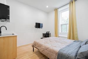 a bedroom with a bed and a flat screen tv at Magnificent Studio with FREE parking near downtown in Montréal +15 photos